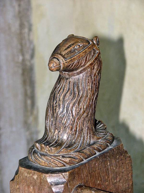 Bench end with muzzled bear motif